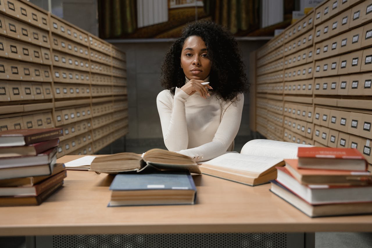 stats-img African American woman studying with books in a library archive area.